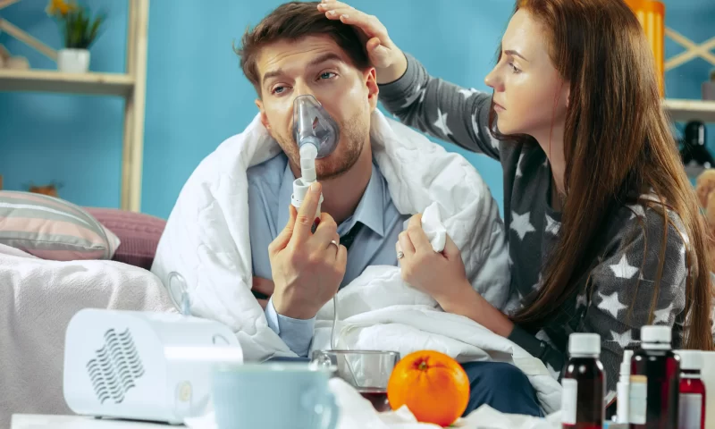 sick-man-with-fever-lying-bed-having-temperature-his-wife-take-care-him-illness-influenza-pain-family-concept-relaxation-home-healthcare-concepts_11zon